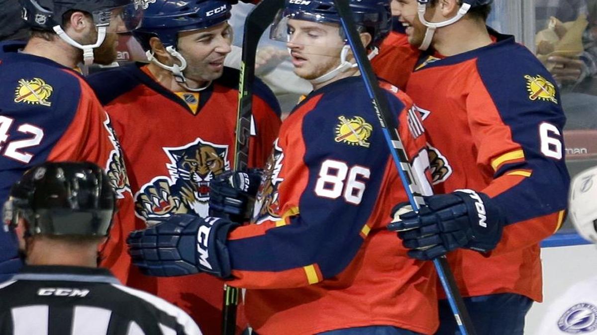 
Florida Panthers center Derek MacKenzie, second from left, is congratulated by teammates Quinton Howden (42), Connor Brickley (86) and Alex Petrovic (6) after MacKenzie scored against the Tampa Bay Lightning in the first period of an NHL preseason game Saturday, Oct. 3, 2015, in Sunrise, Fla.
