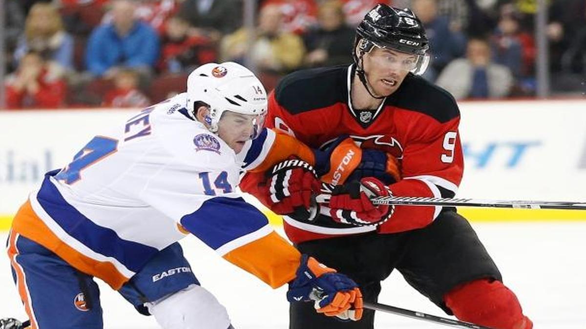
New York Islanders defenseman Thomas Hickey (14) and New Jersey Devils right wing Martin Havlat (9), of the Czech Republic, compete for the puck during the second period Friday, Jan. 9, 2015, in Newark, N.J. 
