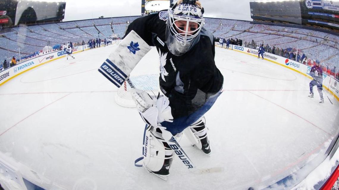 Toronto goalie James Reimer clears a puck during practice on the outdoor rink at the NHL Winter Classic at Michigan Stadium in Ann Arbor, Mich., on Dec. 31, 2013.