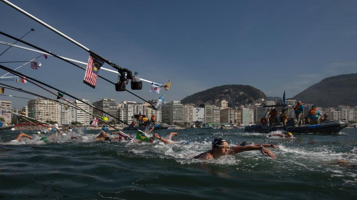 Italy's Rachele Bruni, right, and fellow competitors swim past the feeding station during the women's marathon swimming event at the 2016 Summer Olympics in Copacabana beach, Rio de Janeiro, Brazil, Mon., Aug. 15, 2016.