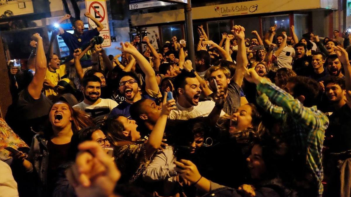 Brazil fans celebrate in the street outside a bar in Copacabana as Brazil beats Germany to win its first gold medal in soccer at the Summer Olympics in Rio de Janeiro on Saturday, Aug. 20, 2016.
