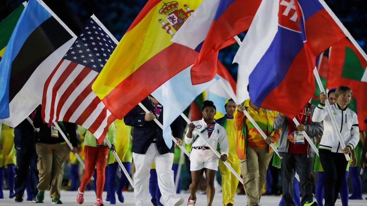 Simone Biles carries the flag of the United States during the closing ceremony in the Maracan stadium at the 2016 Summer Olympics in Rio de Janeiro, Brazil, Sunday, Aug. 21, 2016.