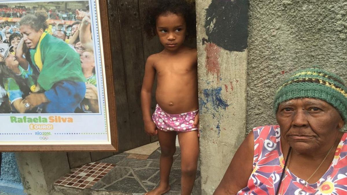 Maria de Conceicao Rosario, right, and Giovanna Silva talk on Aug. 20, 2016, in the City of God slum in Rio de Janeiro, Brazil. They are relatives of judo gold medalist Rafaela Silva and live in her childhood home.