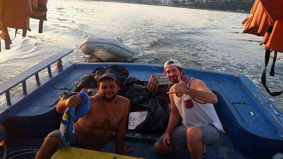Fort Lauderdale’s Brad Funk, right, shows off the bags of trash he and Julio do Outeiral Filho, a fishing boat captain in Niteroi, pulled out of Guanabara Bay recently in preparation for the sailing events in the Rio Olympics.