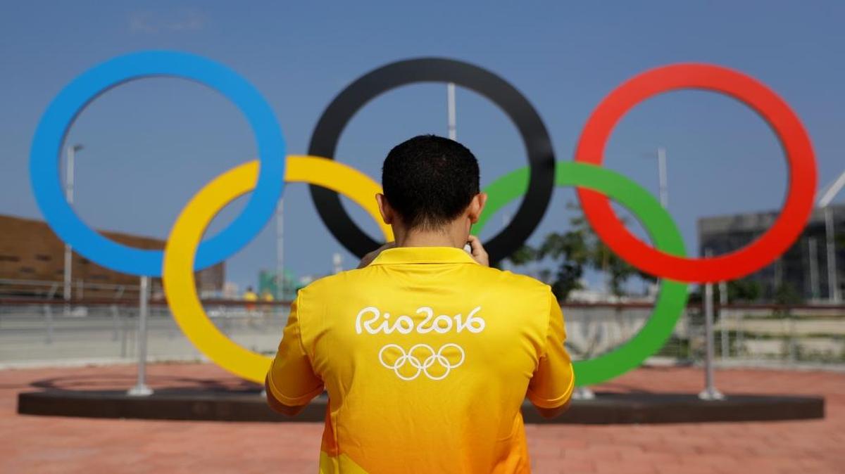 A volunteer photographs a set of Olympic Rings at Olympic Park in Rio de Janeiro, Brazil, Friday, July 29, 2016.
