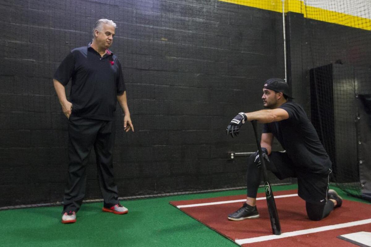Lorenzo Garmendia, left, and Eddy Alvarez take a rest after Alvarez practiced his swing at a gym in Doral on Tuesday, Jan. 30, 2018.
