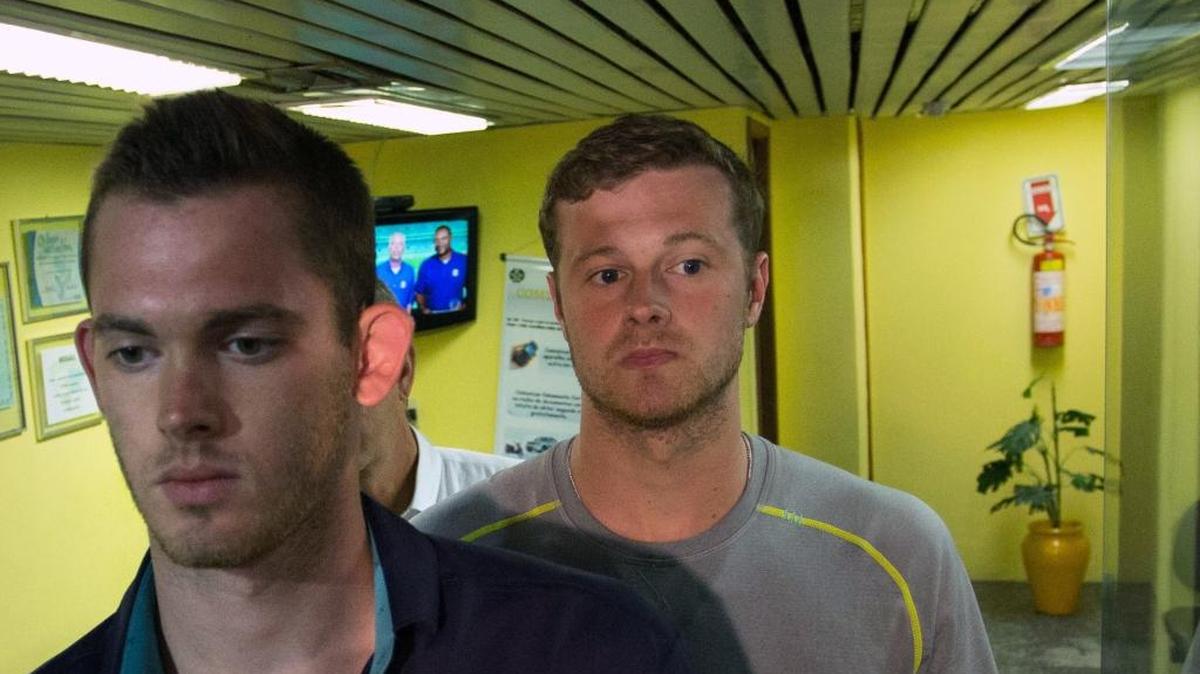 American Olympic swimmers Gunnar Bentz, left, and Jack Conger, center, after they were taken off their flight from Brazil to the U.S. on Wednesday.