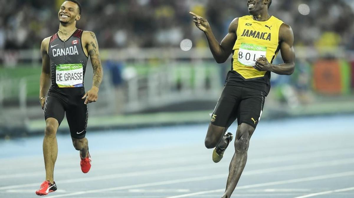 Jamaica’s Usain Bolt, right, laughs with Canada’s Andre deGrasse as the two cross the finish line in the semifinals of the men’s 200 meters on Thursday at Olympic Stadium during the 2016 Summer Olympics Games in Rio de Janeiro, Brazil.