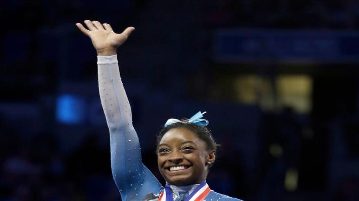Simone Biles waves after being named overall winner in the U.S. women's gymnastics championships Sunday, June 26, 2016, in St. Louis.
