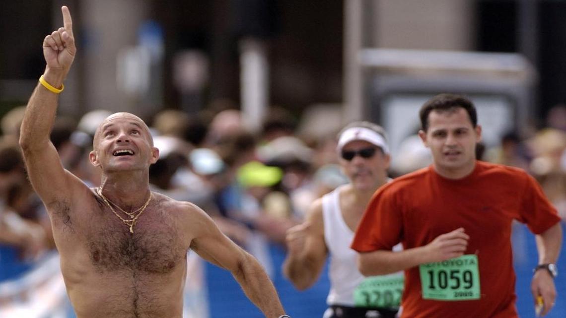 Alexis Garcia points skyward in dedication to his deceased father, a former runner, as Garcia approaches the finish line of the 2005 Miami Marathon. On Sunday, he will run in his 15th 26.2-miler.