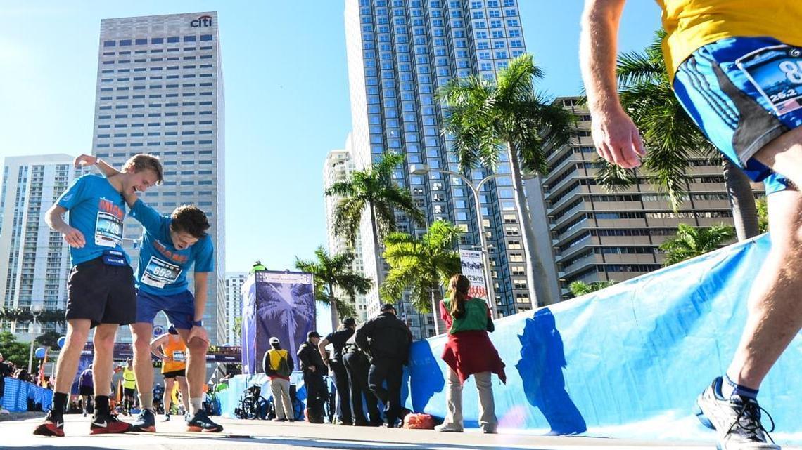 Guillaume Mott lends his shoulder to Antony Mott after crossing the finish line during the 2015 Miami Marathon & Half Marathon on Sunday, Jan. 25, 2015.