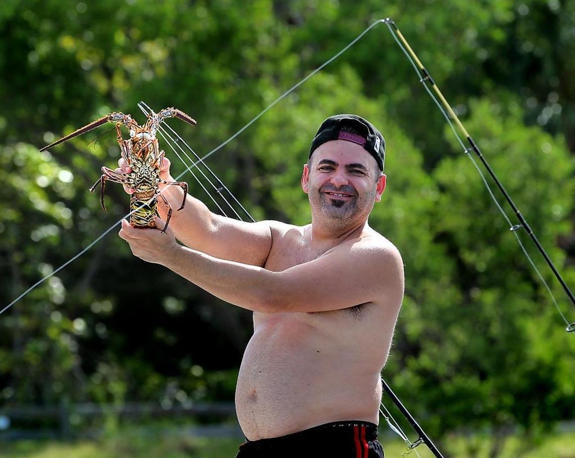 Andrea Fadda proudly shows off his catch off Key Biscayne during the state's two-day lobster mini-season on Wednesday, July 26, 2017.