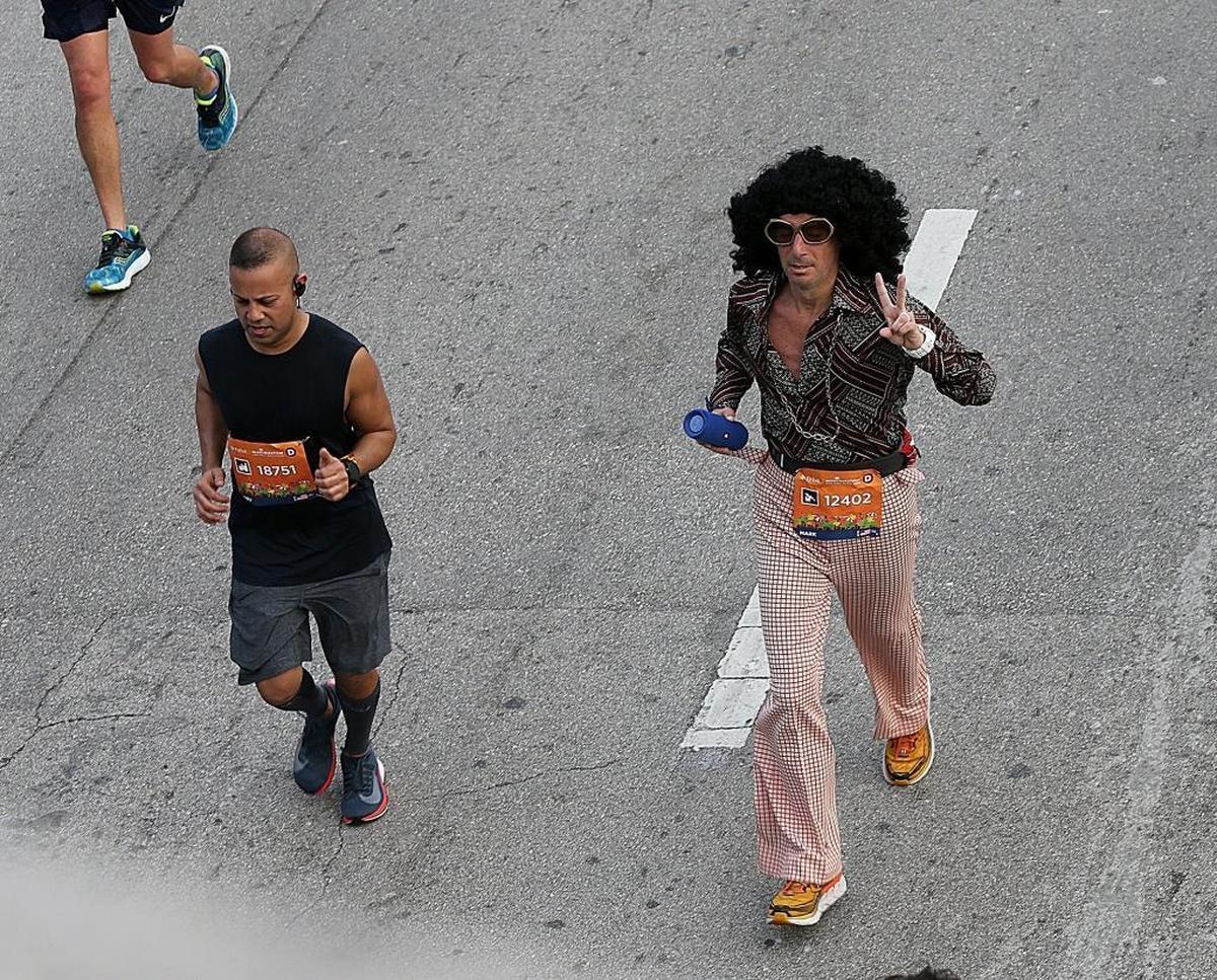 A runner wears a retro ’70s outfit as he runs along NW Third Ave. during the Miami Marathon 2018 on Sunday, Jan. 28.