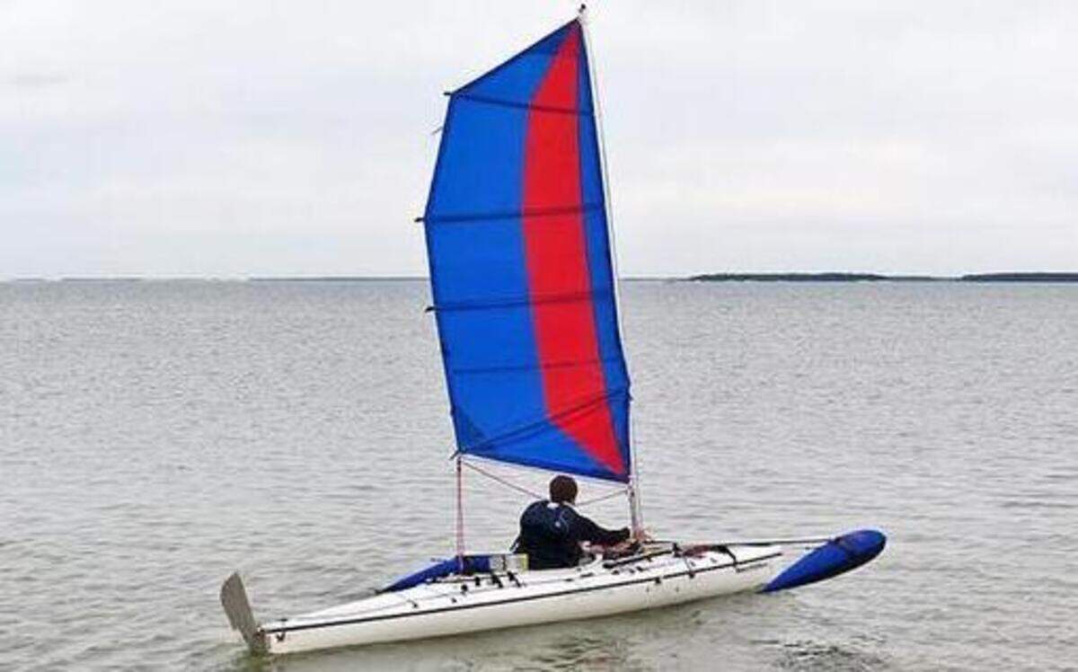 
Josh Morgan sails away from Pavilion Key aboard a custom-built canoe with a sail and outriggers.
