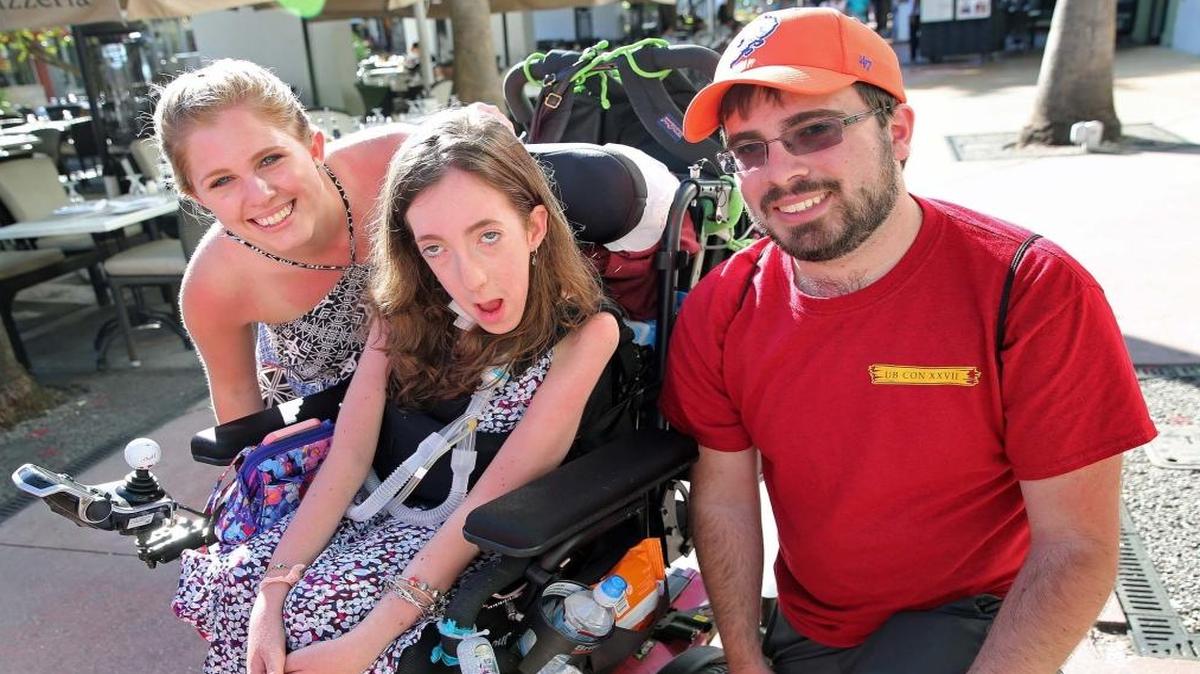 Miami Marathon participant Peri Finkelstein, 17, who has muscular dystrophy and intends to walk the final mile of the marathon with her walker as she's taking in the sights on Lincoln Road Mall. She's been training in her basement in New York and now in the hallways of Eden Roc Hotel in Miami Beach on Wed. Jan. 25, 2017 as her sister Katy, 42, left and her brother Joel, 21, pose with her and will also run with her.