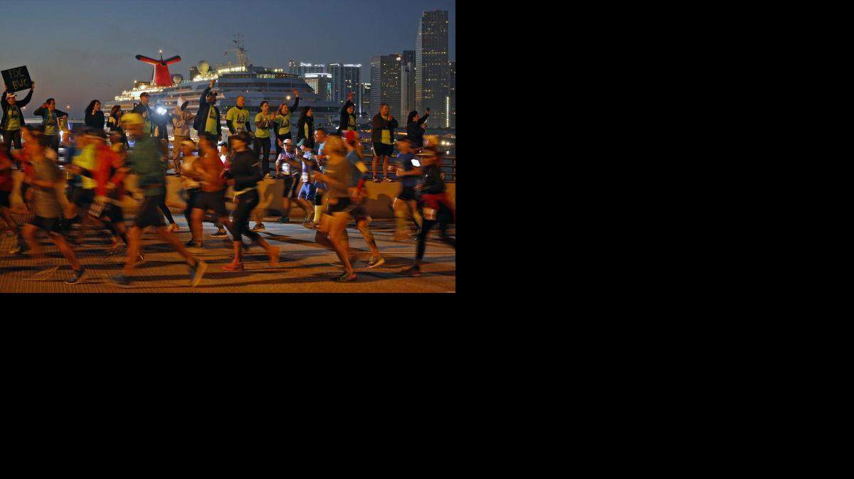 
Supporters stand on retainer wall cheering on participants as begin their descent on the MacArthur Causeway heading east towards Miami Beach. Thousands ran, jogged, and walked during the Miami Marathon and Half Marathon on Sunday, January 25, 2015 in Miami, Florida.
