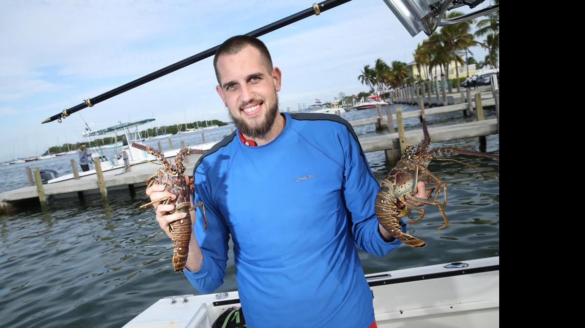 
Ray Valdes, of Hialeah, holds up a few of the lobsters that he and some friends caught during lobster miniseason Wednesday morning at Crandon Park Marina 
