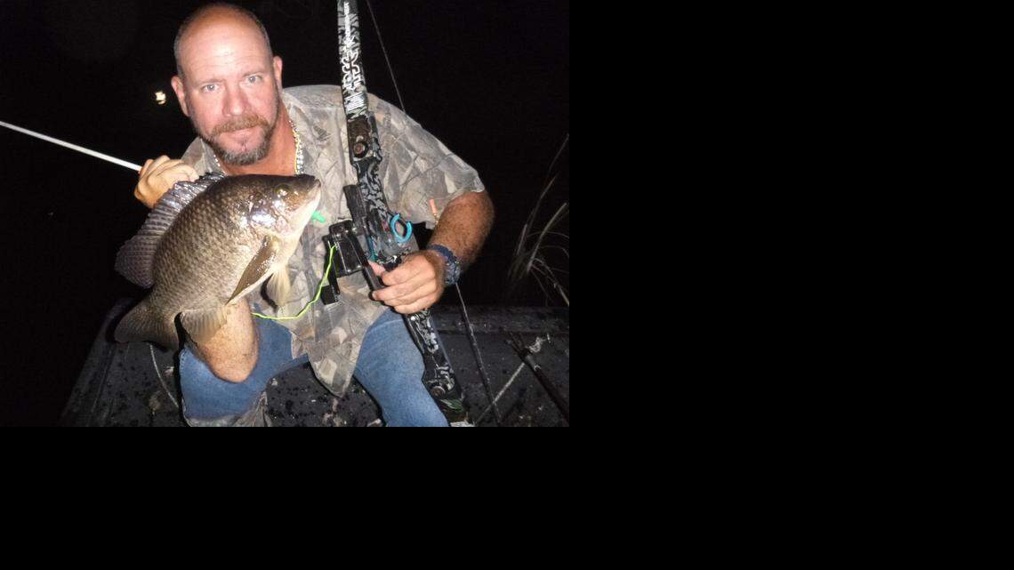 
Stuck on you: Captain Jason Peters displays a blue tilapia he shot with bow and arrow in the Everglades during a recent excursion.
