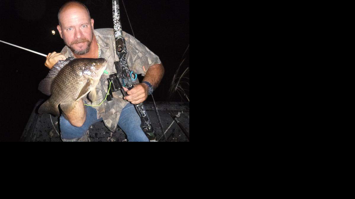 
Stuck on you: Captain Jason Peters displays a blue tilapia he shot with bow and arrow in the Everglades during a recent excursion.
