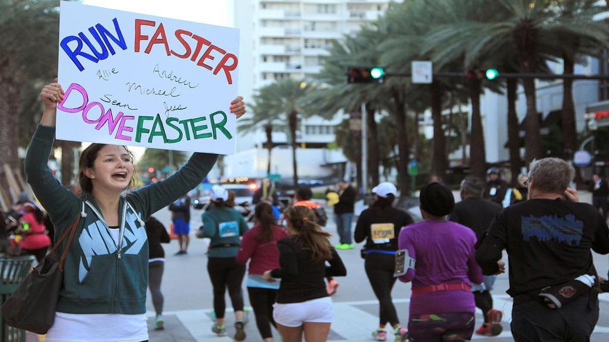 Julia Murphy, left, encourages Miami Marathon runners as they make their way up Collins Avenue in Miami Beach during the 2016 Miami Marathon and Half Marathon.