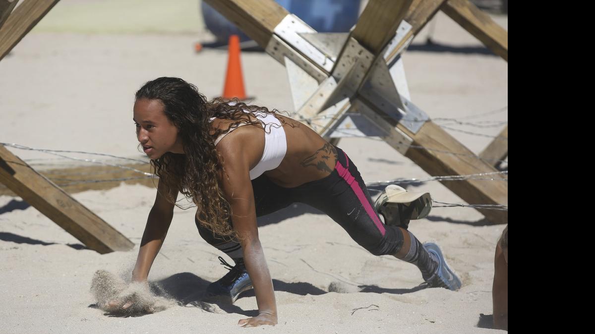 
Sweetwater’s Lily Garcia takes on a barbed-wire obstacle in a BattleFrog obstacle course race at Lummus Park in South Beach in 2014. The series returns to Miami on Nov. 21 at Amelia Earhart Park.

