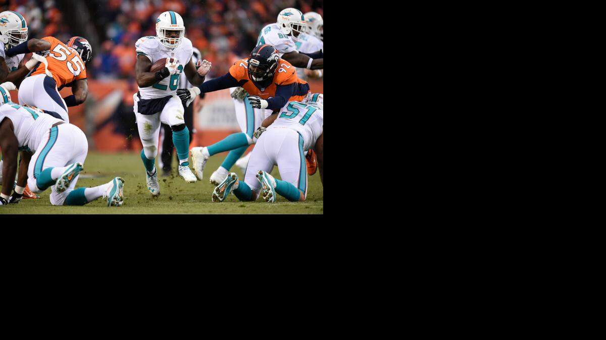
Miami Dolphins running back Lamar Miller gains yardage against the Denver Broncos during their game on Nov. 23, 2014.

