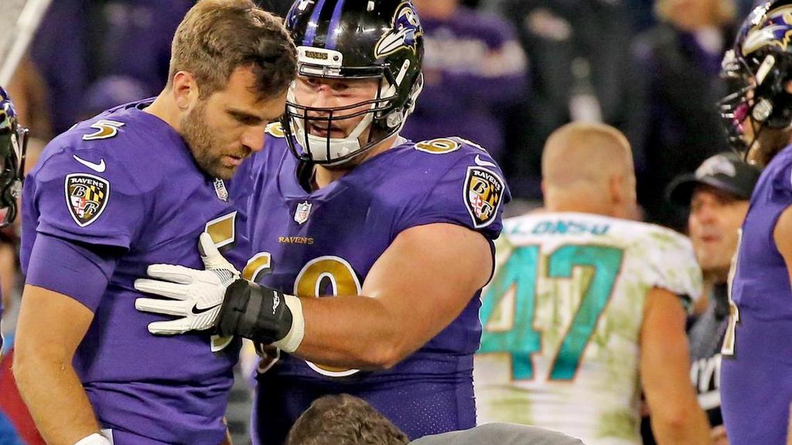 Baltimore Ravens quarterback Joe Flacco gets up slowly with help from Matt Skura after being hit by Miami Dolphins linebacker Kiko Alonso.