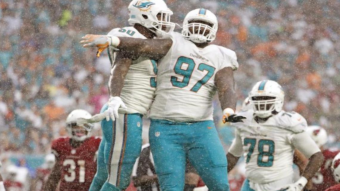 Miami Dolphins defensive end Andre Branch (50) and Miami Dolphins defensive tackle Jordan Phillips (97) celebrate after Branch causes a fumble by Arizona Cardinals quarterback Carson Palmer (3) in the third quarter as the Miami Dolphins host Arizona Cardinals at Hard Rock Stadium on Sunday, Dec. 11, 2016.