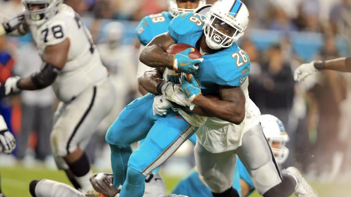 Miami Dolphins running back Damien Williams runs for a first down against Oakland but the Dolphins don’t run nearly enough on the road.