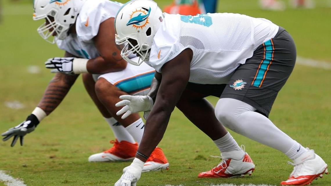Dolphins’ Laremy Tunsil, right, lines up during line drills Sunday, Aug. 14, 2016.