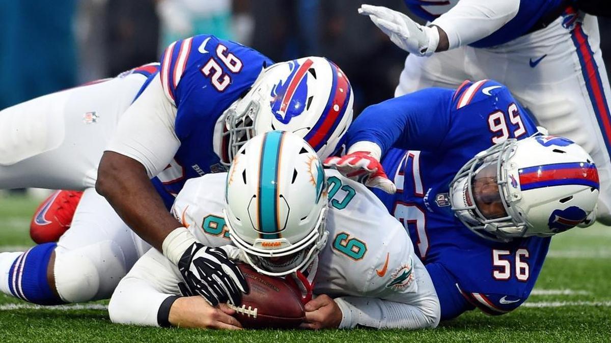 Miami Dolphins quarterback Jay Cutler (6) recovers the ball as Buffalo Bills' Adolphus Washington (92) and Ryan Davis (56) close in during the second half of an NFL football game Sun., Dec. 17, 2017, in Orchard Park, N.Y.