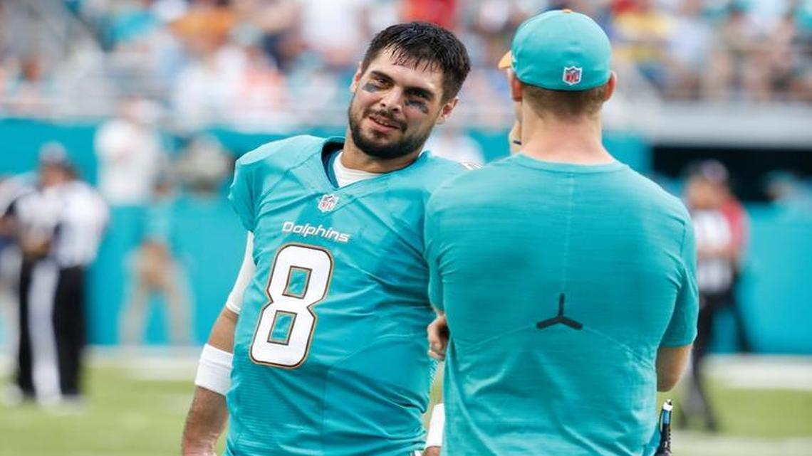 Miami Dolphins quarterback Matt Moore (8) with injured quarterback Ryan Tannehill (17) on the sidelines as the Miami Dolphins host the New England Patriots at Hard Rock Stadium on Sunday, January 1, 2017.