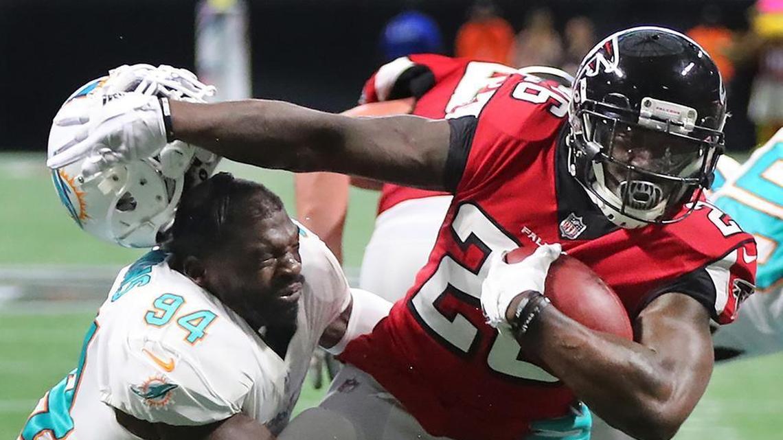 Atlanta Falcons running back Tevin Coleman separates Miami Dolphins linebacker Lawrence Timmons from his helmet in 2017.