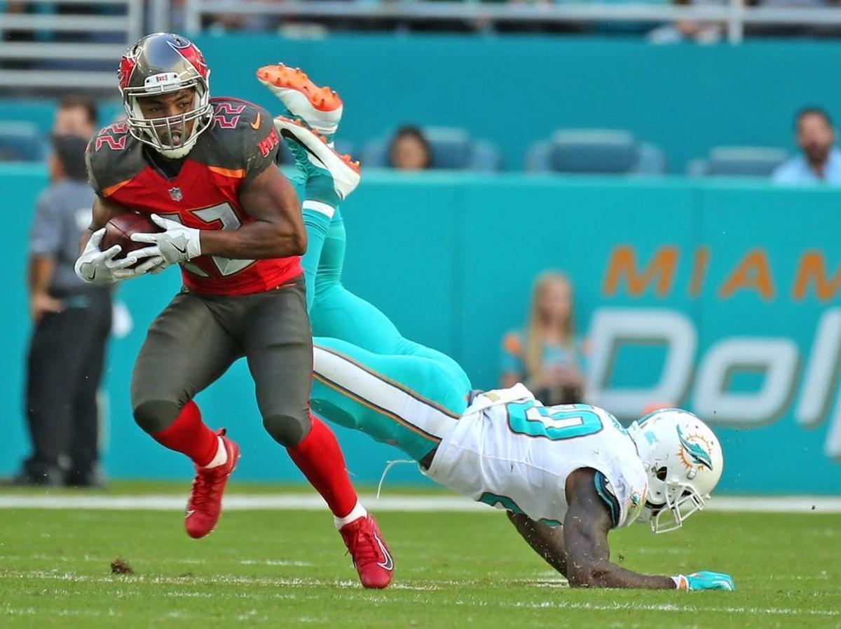 Miami Dolphins Reshad Jones (20) misses a tackle as Tampa Bay Buccaneers Doug Martin (22) runs up field in second quarter at Hard Rock Stadium in Miami Gardens, Florida, Nov. 19, 2017.