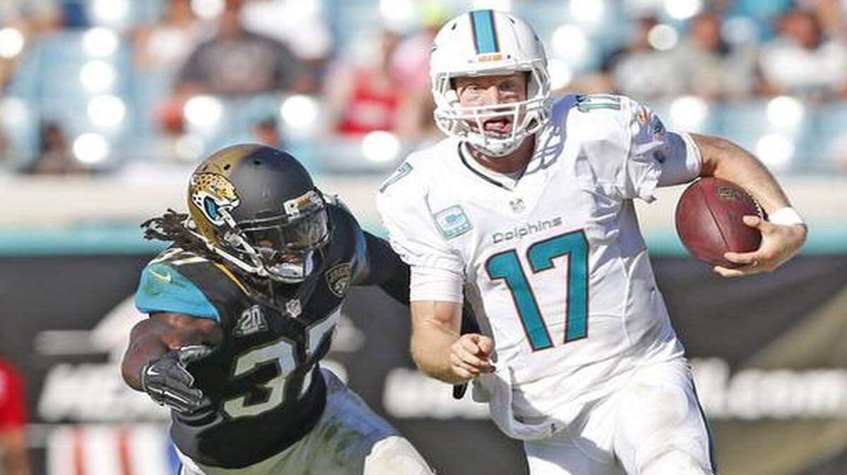 
Turning the corner: Dolphins quarterback Ryan Tannehill scrambles for a first down in the fourth quarter against the Jaguars. The Dolphins struggled against a Jacksonville defense that was 27th in the NFL in points allowed. 
