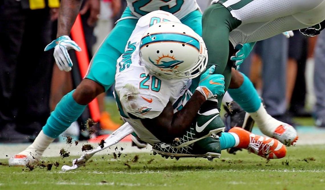 Miami Dolphins Reshad Jones (20) tackles a New York Jets player at Hard Rock Stadium in Miami Gardens, Fla., Oct. 22, 2017.