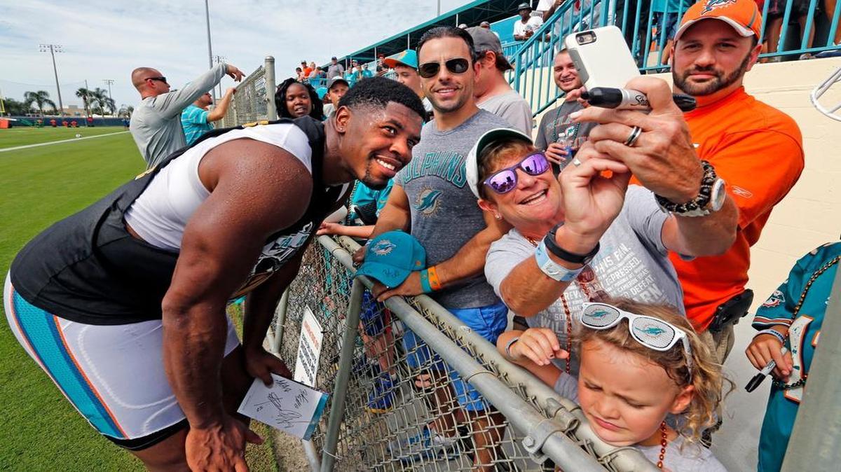 
Dolphins defensive end Cameron Wake poses for a selfie with fan Leslie Furman after practice on Day 1 of Miami Dolphins training camp Thursday, July 30, 2015 in Davie.
