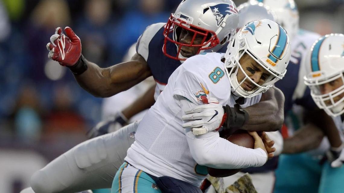 New England Patriots cornerback Jonathan Jones, rear, sacks Miami Dolphins quarterback Matt Moore during the second half of an NFL football game, Sunday, Nov. 26, 2017, in Foxborough, Mass.