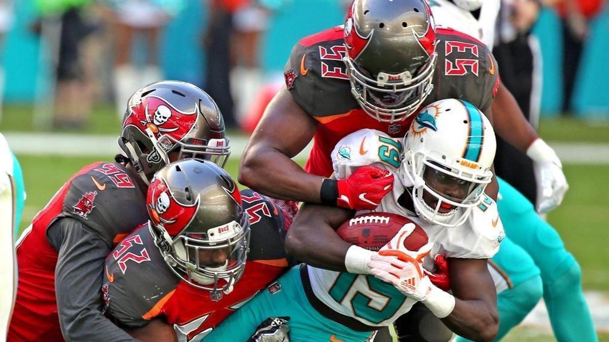 The Miami Dolphins’ Jakeem Grant (19) gets swamped by Tampa Bay Buccaneers players on a kick return in the second quarter at Hard Rock Stadium in Miami Gardens, Florida, Nov. 19, 2017.