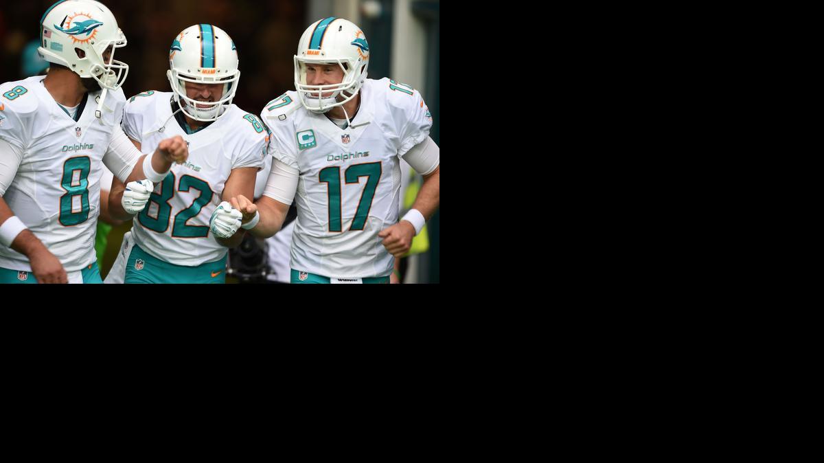 
Miami Dolphins' Ryan Tannehill, right, Matt Moore, left, and Brian Hartline run onto the field to warm up before the NFL football game against Oakland Raiders at Wembley Stadium in London, Sunday, Sept. 28, 2014. 
