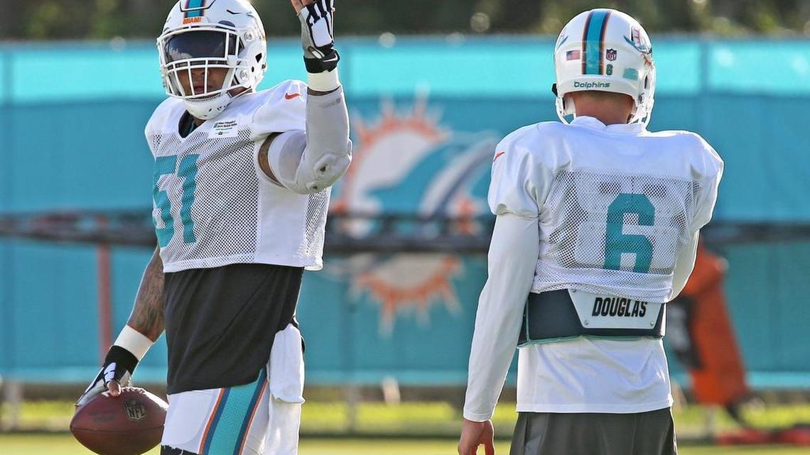 Miami Dolphins Mike Pouncey prepares for a snap drill with quarterback Brandon Doughty during training camp at the Miami Dolphins training facility in Davie.