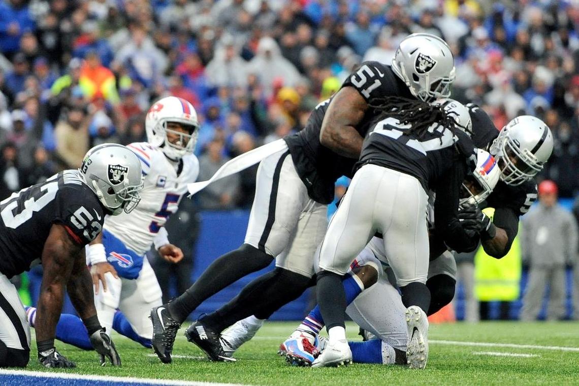 Buffalo Bills running back LeSean McCoy, second form right, is stuffed by Oakland Raiders free safety Reggie Nelson (27), outside linebacker Bruce Irvin (51) and defensive end Khalil Mack, far right, during the second half of an NFL football game, Sun., Oct. 29, 2017, in Orchard Park, N.J.