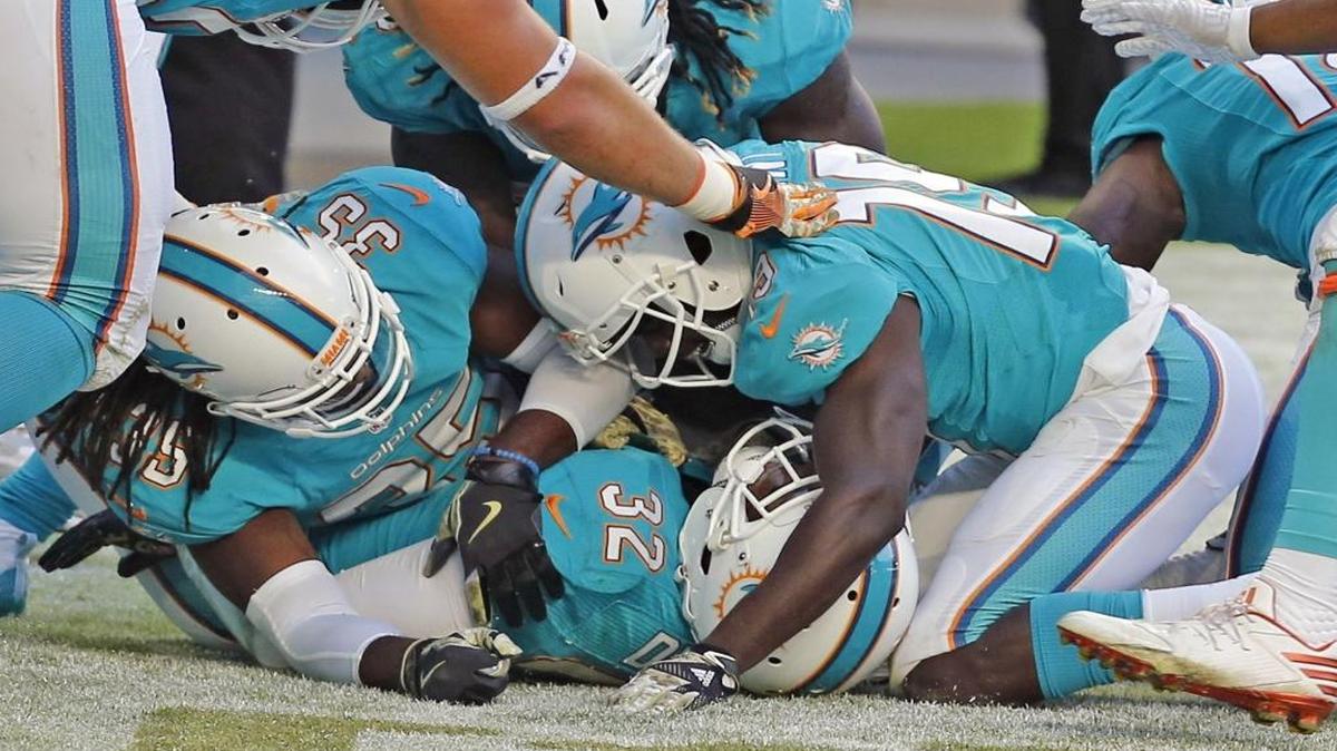 Miami Dolphins Jakeem Grant and, 19, and Tony Lippet, 35, pile onto Kenyan Drake, 32, after Drake scored a fourth quarter touchdown as they play the New York Jets at Hard Rock Stadium in Miami Gardens, Florida on Sun., Nov. 6, 2016.