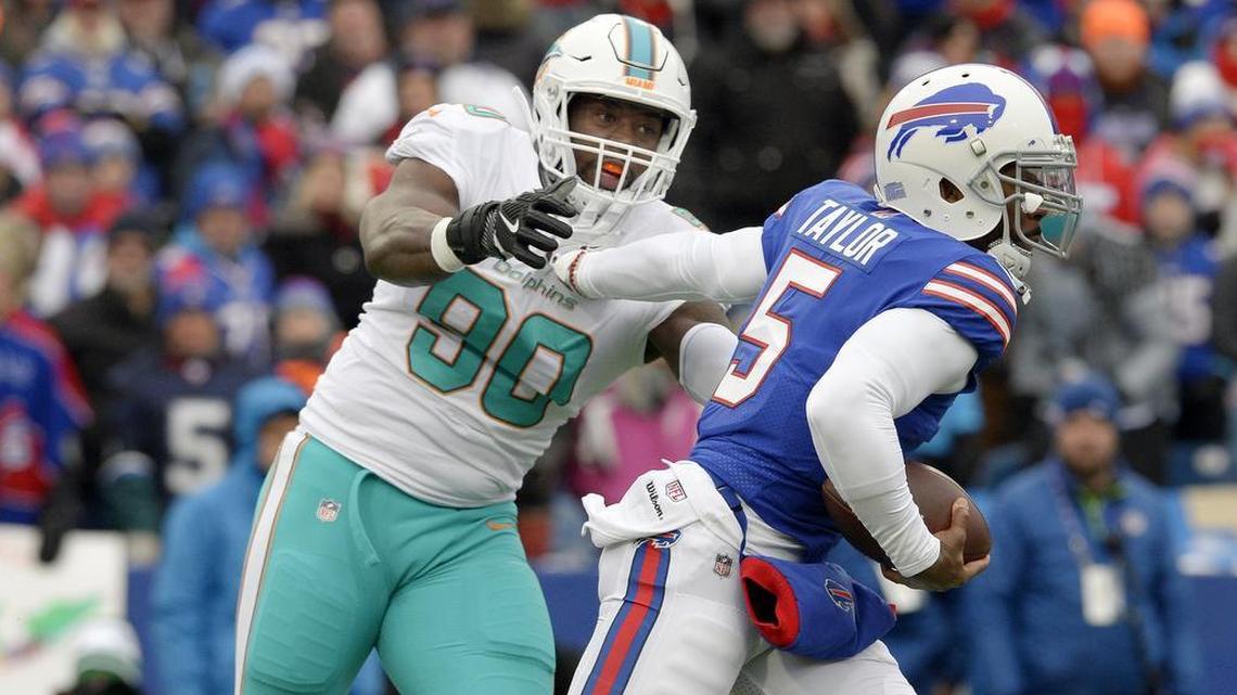 Buffalo Bills quarterback Tyrod Taylor eludes Miami Dolphins defensive end Charles Harris.