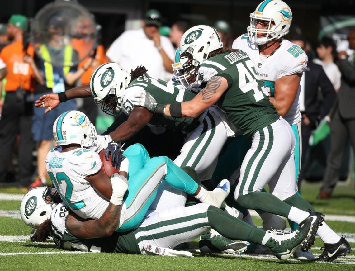 New York Jets defensive end Leonard Williams (92) and teammates take down Miami Dolphins running back Kenyan Drake (32) in the fourth quarter as the New York Jets host the Miami Dolphins at Met Life Stadium on Sun., Sept. 24, 2017.