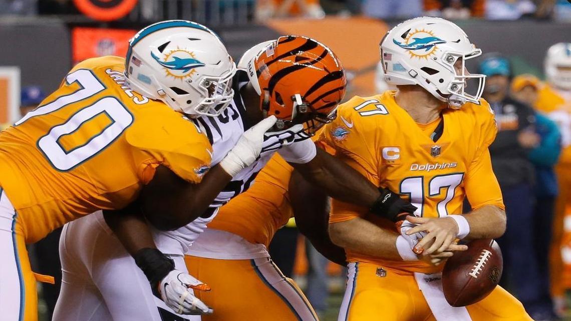 Bengals defensive end Carlos Dunlap, second from left, strips Dolphins quarterback Ryan Tannehill of the ball during the first half of Thursday night’s game in Cincinnati. The Bengals recovered the fumble.