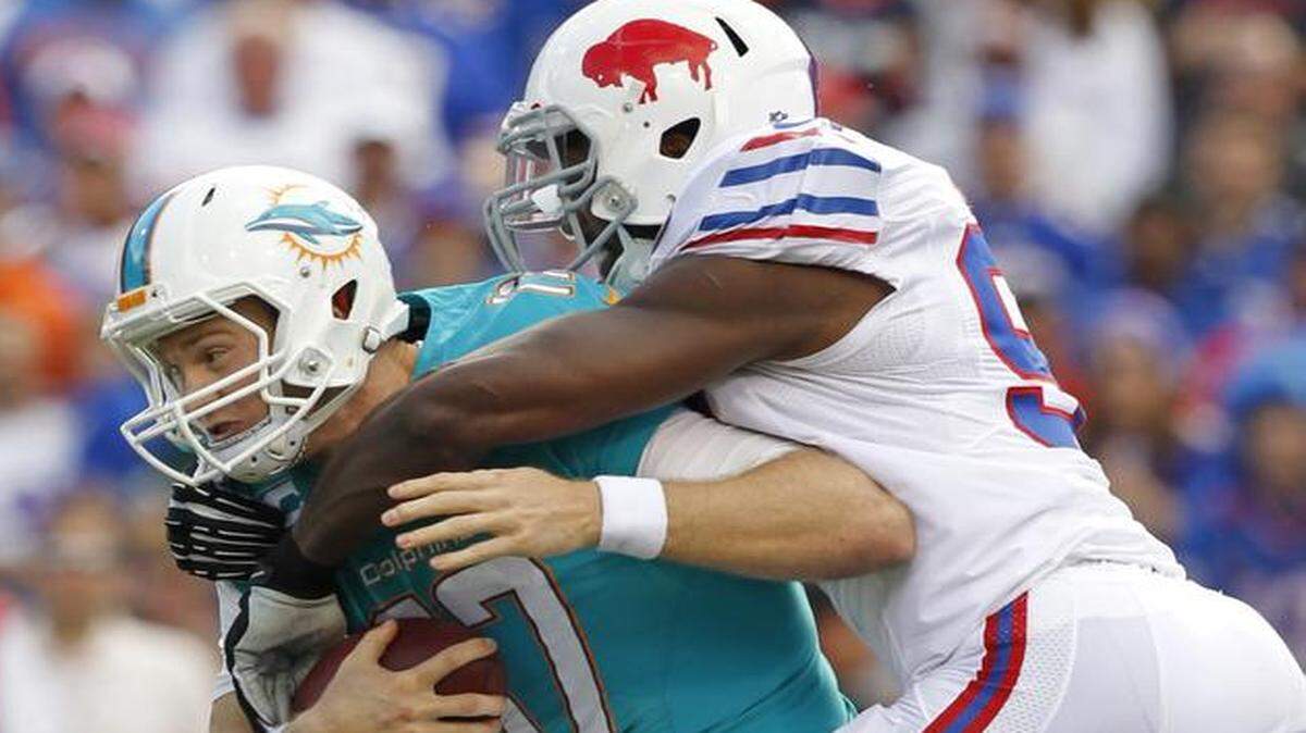 
Miami Dolphins quarterback Ryan Tannehill is taken down by Buffalo Bills defensive end Manny Lawson after gaining 5 yards in the fourth quarter at Ralph Wilson Stadium on Sunday, Sept. 14, 2014.
