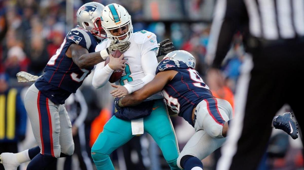 New England Patriots linebacker Marquis Flowers, left, and defensive end Trey Flowers, right, sack Miami Dolphins quarterback Matt Moore, center, during the second half of an NFL football game on Sunday, Nov. 26, 2017, in Foxborough, Massachusetts.