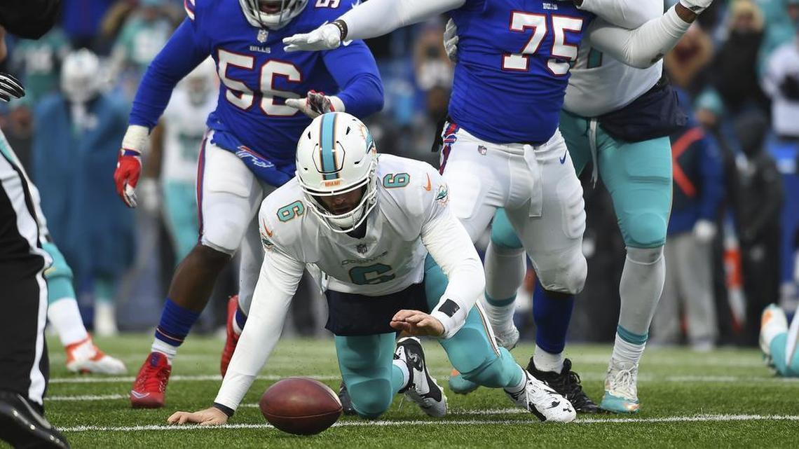 Miami Dolphins quarterback Jay Cutler attempts to recover his own fumble as Buffalo Bills defenders try to close in on him last Sunday.
