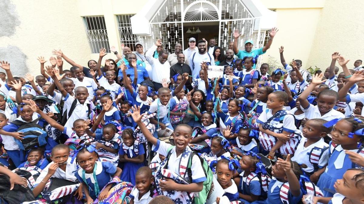 The Dolphins’ travel party poses with students from the Ecole Mixte Priestly Sainte Claire of Assisi school in Port-au-Prince.